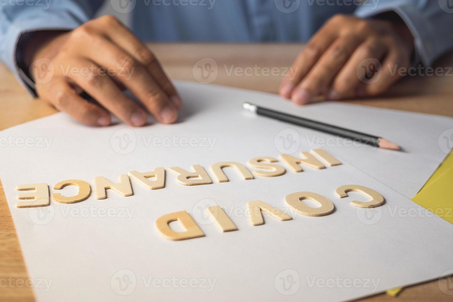 courtier présente sur l'assurance covid. textes en bois sur les documents. gros plan moyen avec espace de copie. photo