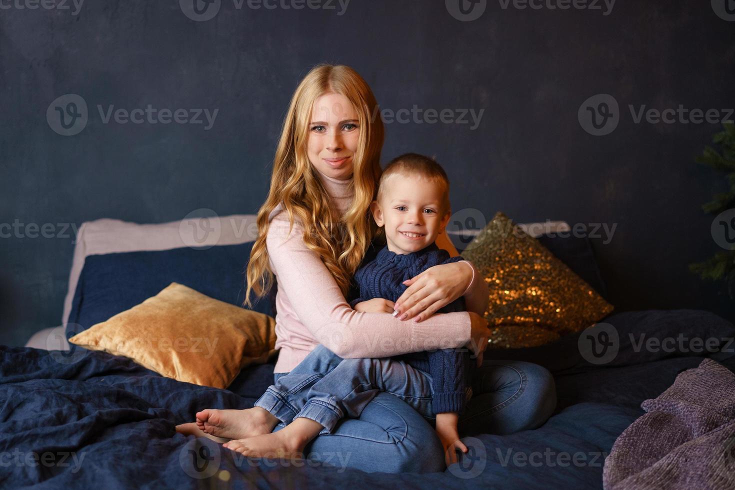 maman et petit fils assis sur le lit dans une étreinte. photo