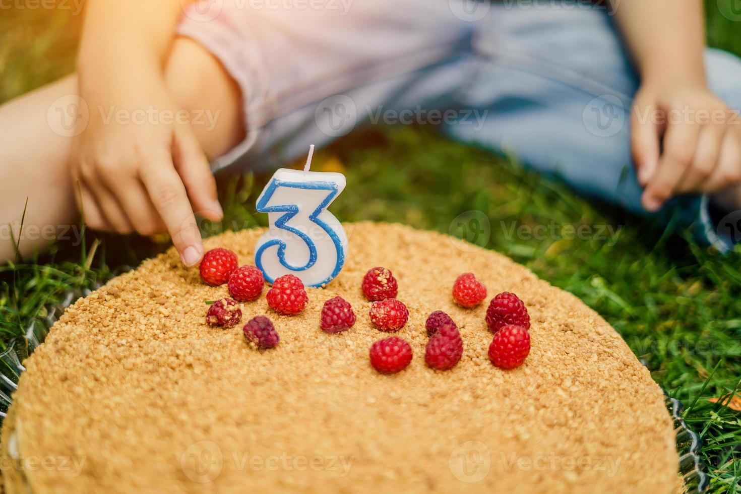 gâteau aux framboises pour un enfant de trois ans en gros plan photo