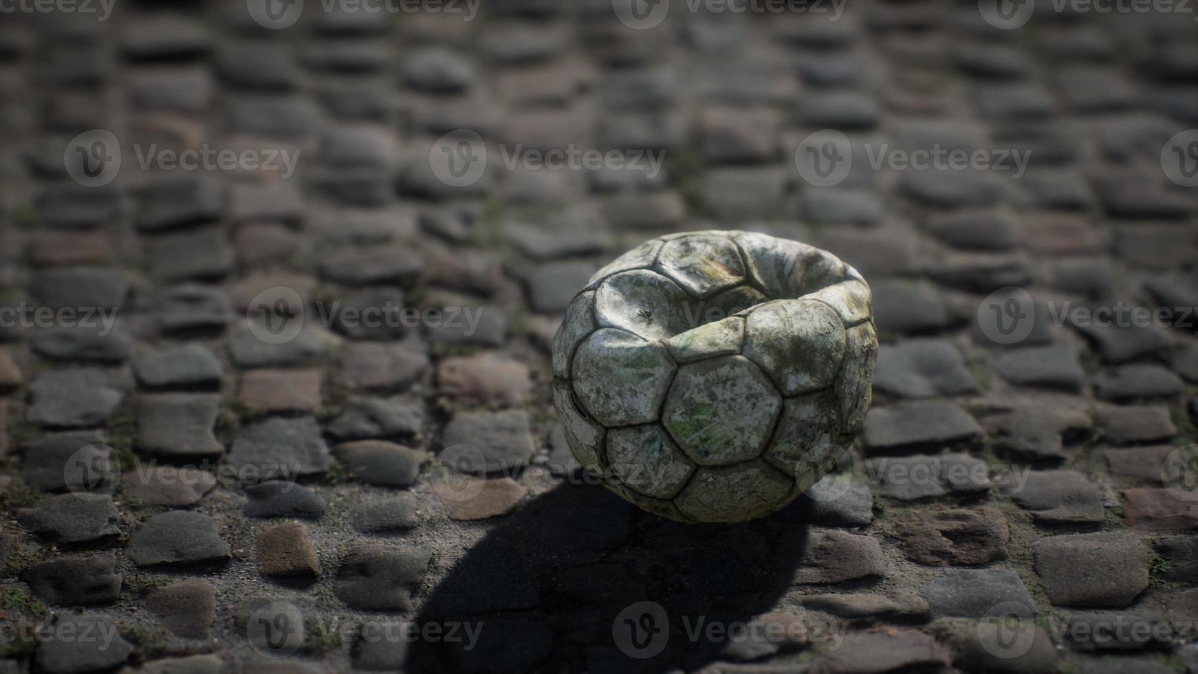 vieux ballon de football dans la cour de la chaussée photo