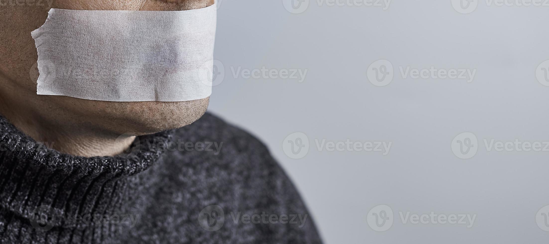 homme réduit au silence avec du ruban adhésif sur la bouche. photo avec espace de copie.