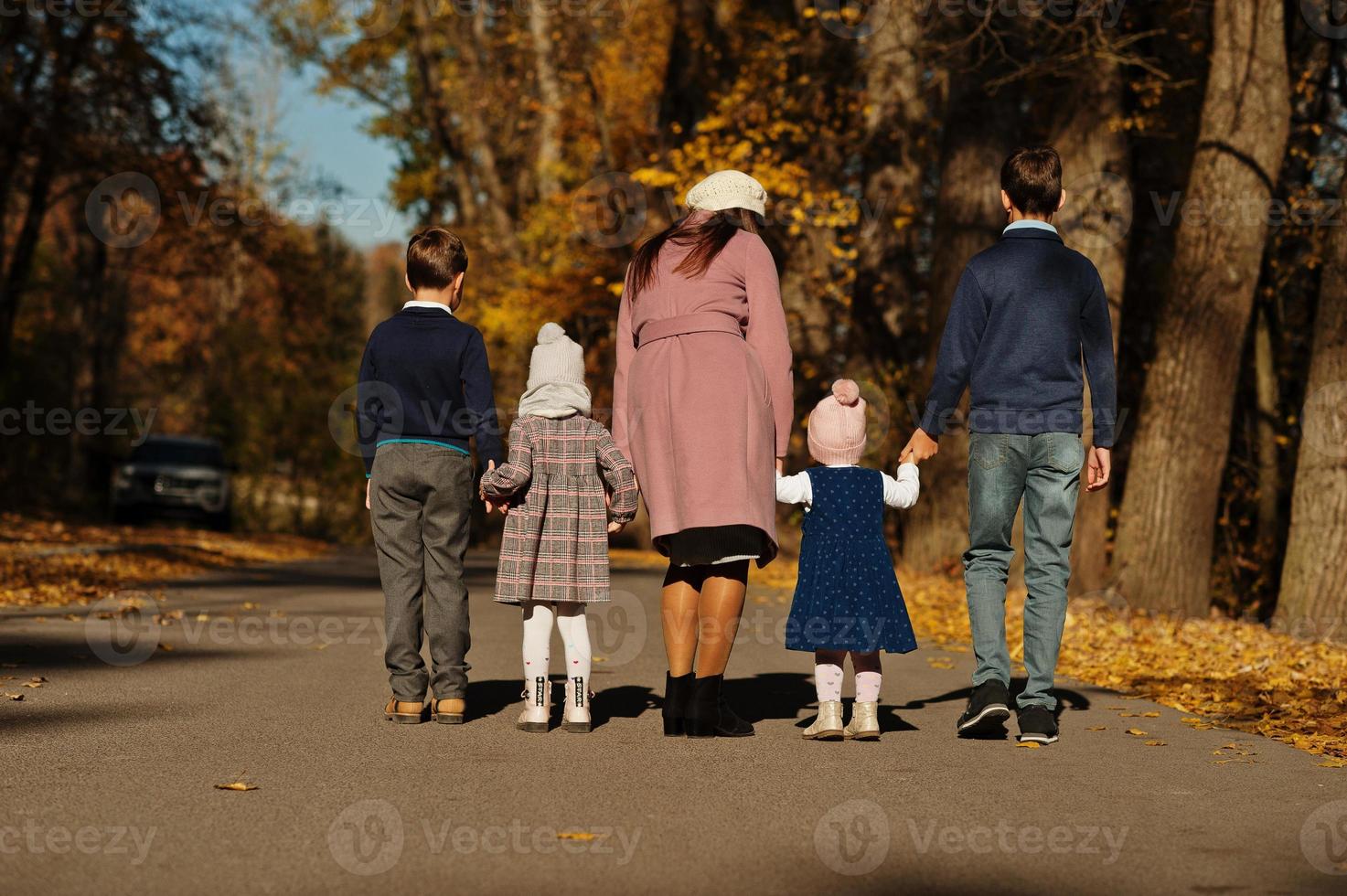 dos de mère avec quatre enfants sur le parc d'automne. photo
