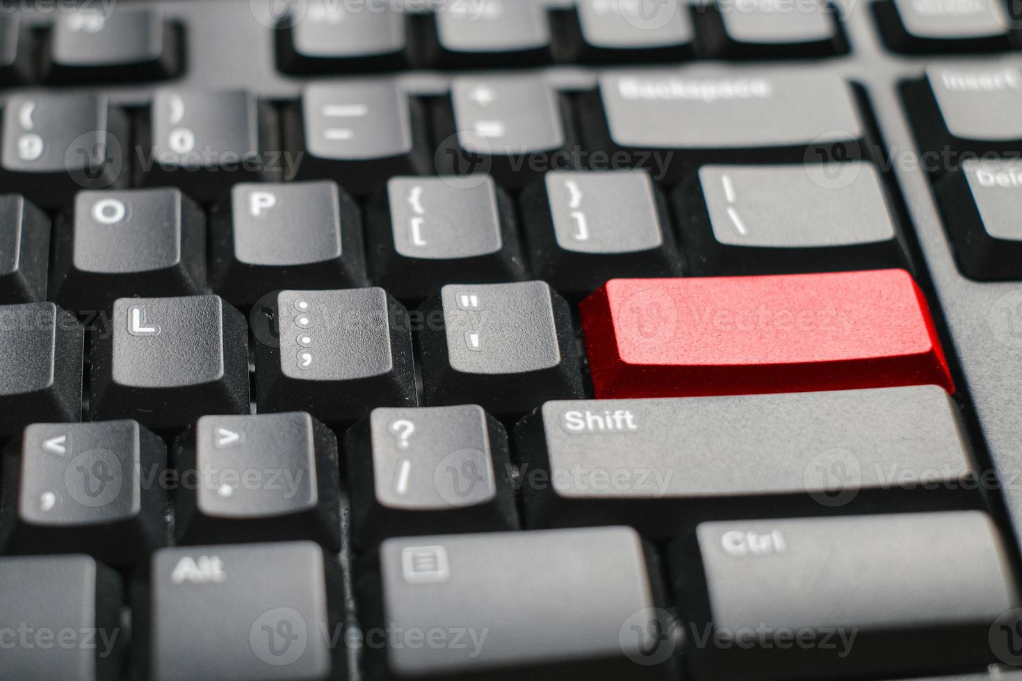 Vue rapprochée d'un clavier d'ordinateur portable avec un bouton rouge sur le tableau blanc du bureau photo