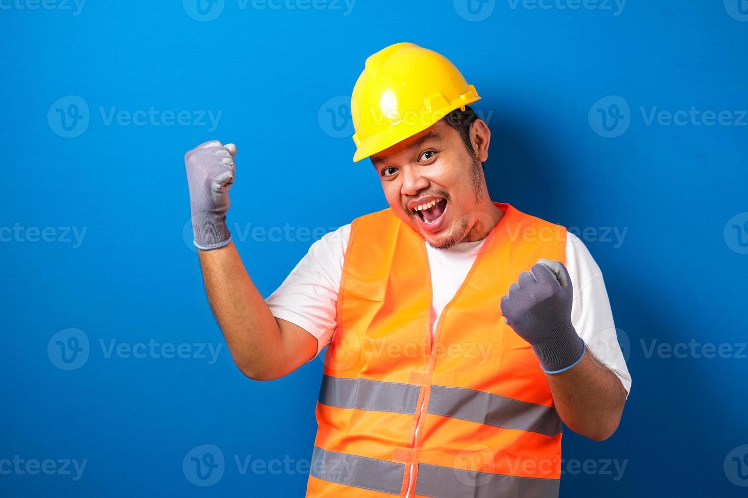 un travailleur asiatique portant un casque de sécurité a l'air heureux de célébrer sa victoire photo