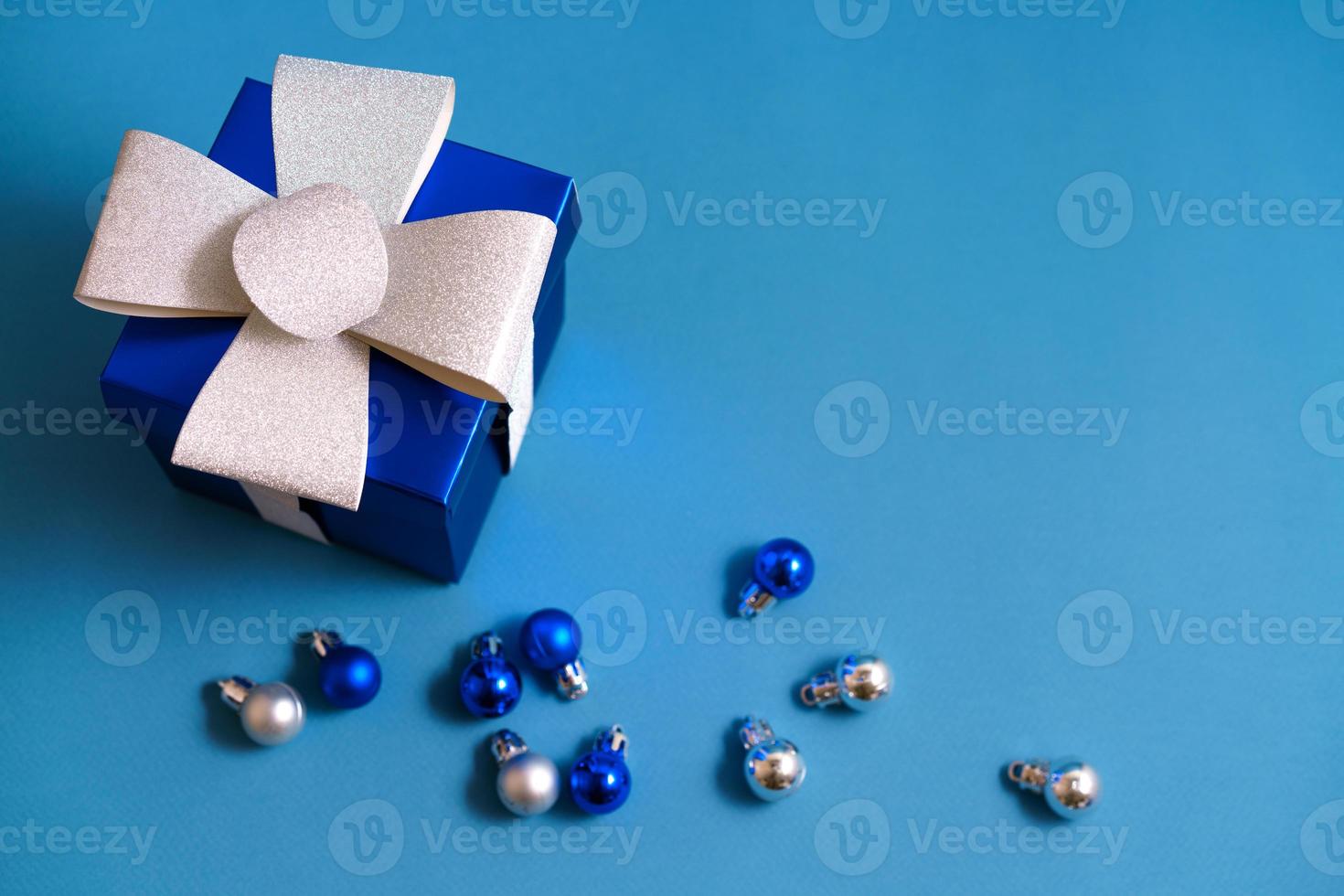 coffret cadeau bleu avec des boules de noël sur fond bleu photo