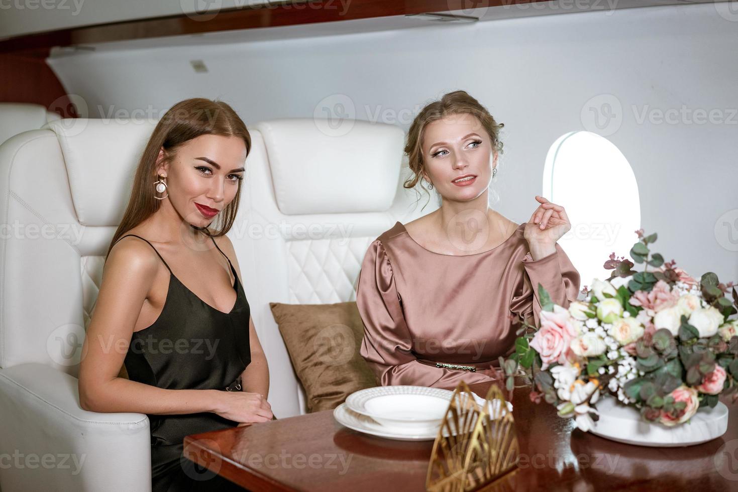 deux femmes d'affaires heureuses assises dans un avion privé à la table photo