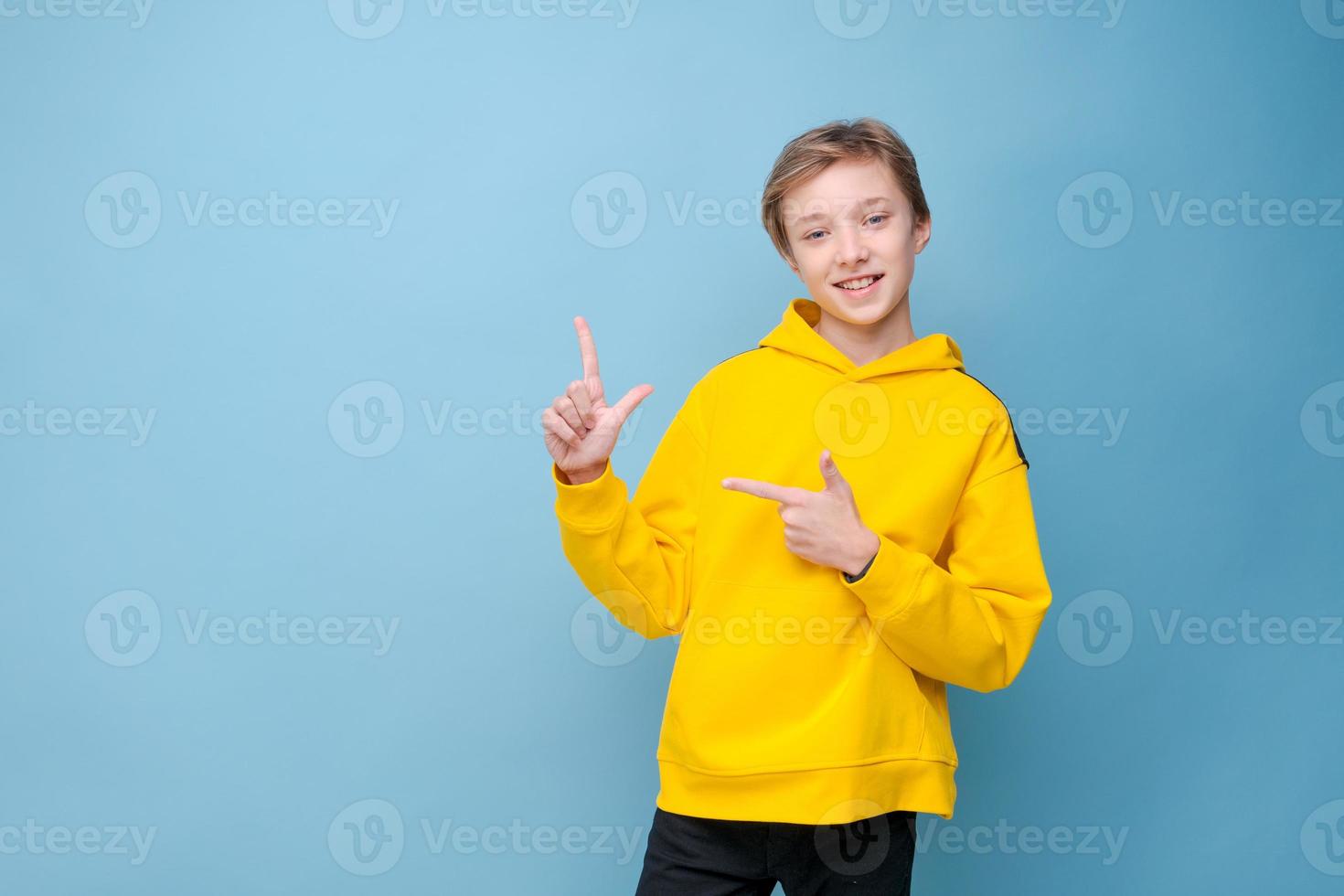 heureux joyeux souriant jeune homme de race blanche aux cheveux blonds, vêtu d'un jaune photo