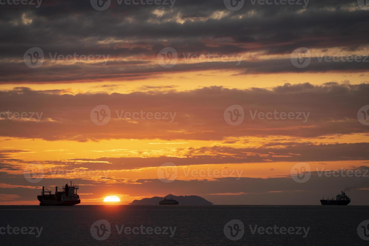 coucher de soleil fantastique avec des navires une île et trois navires en contre-jour photo