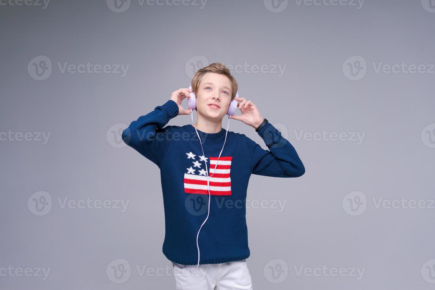 Portrait Caucasian guy adolescent écoute de la musique avec des écouteurs en bleu photo