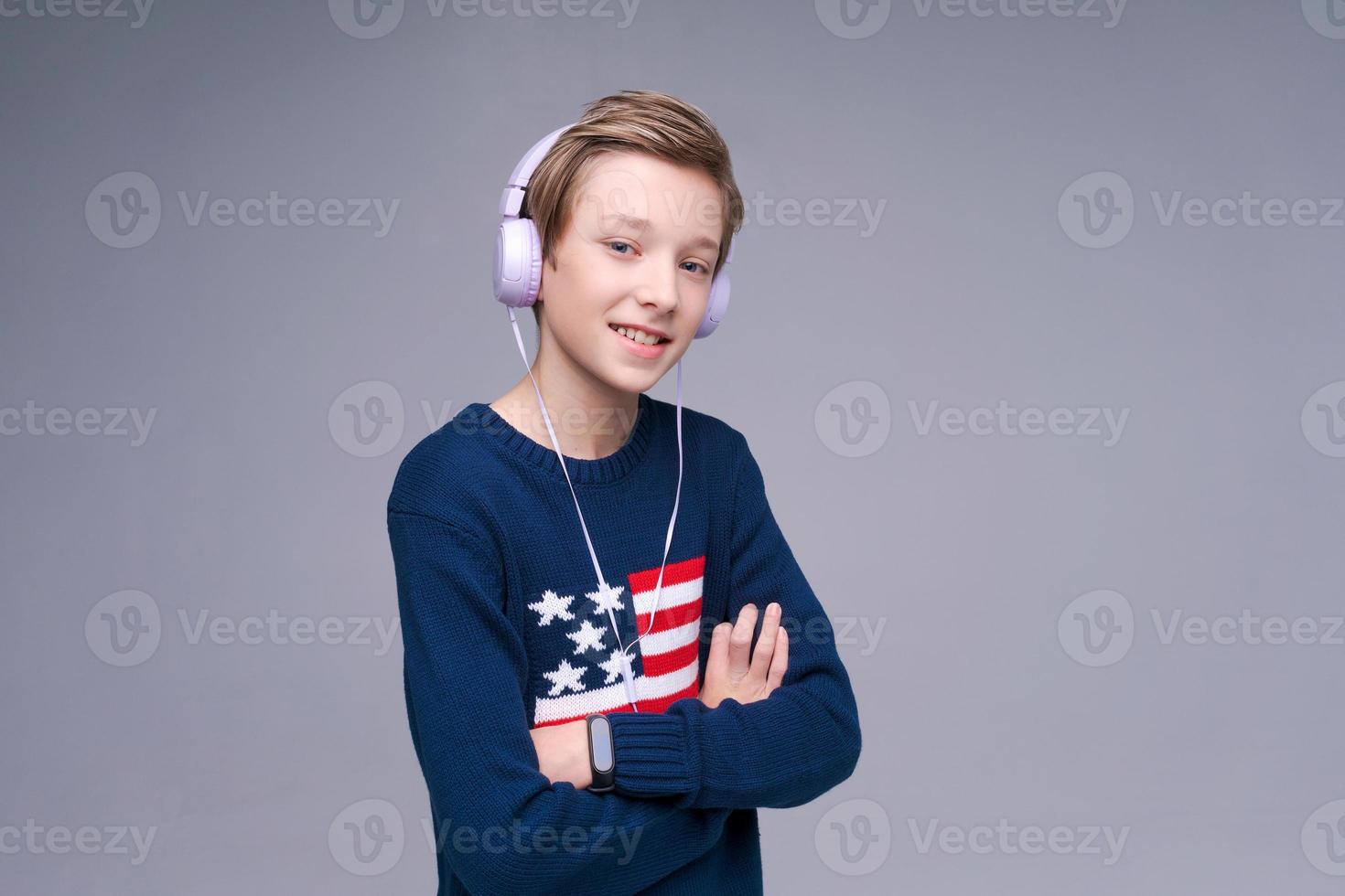 Portrait Caucasian guy adolescent écoute de la musique avec des écouteurs en bleu photo