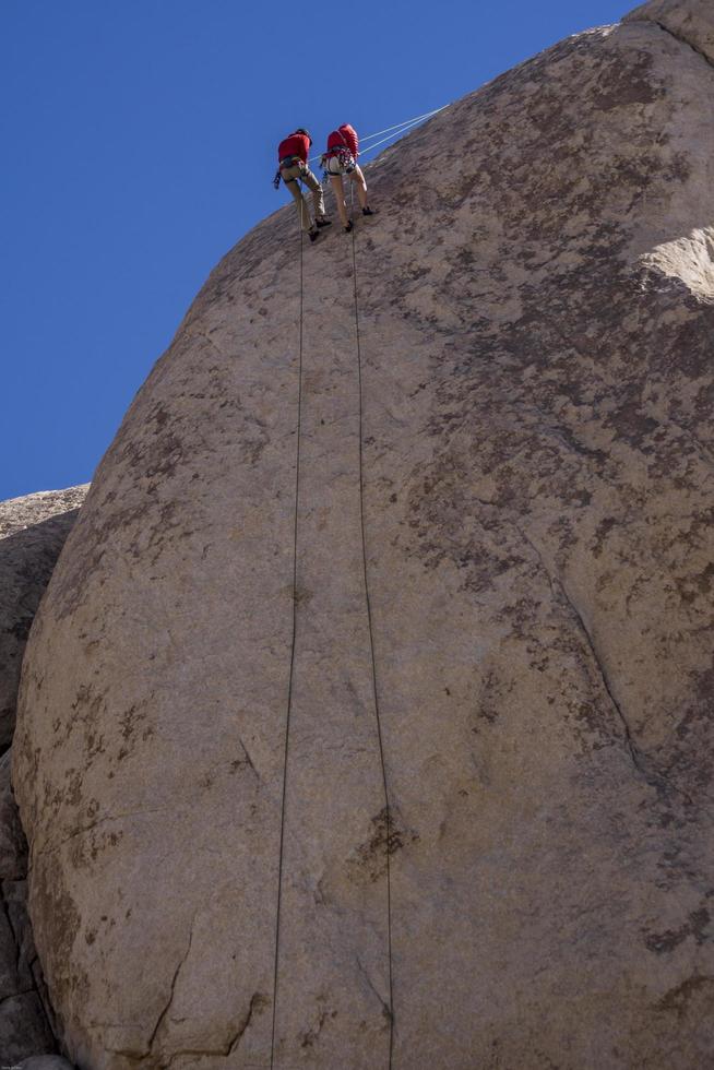 grimpeurs descendant en rappel une paroi rocheuse photo