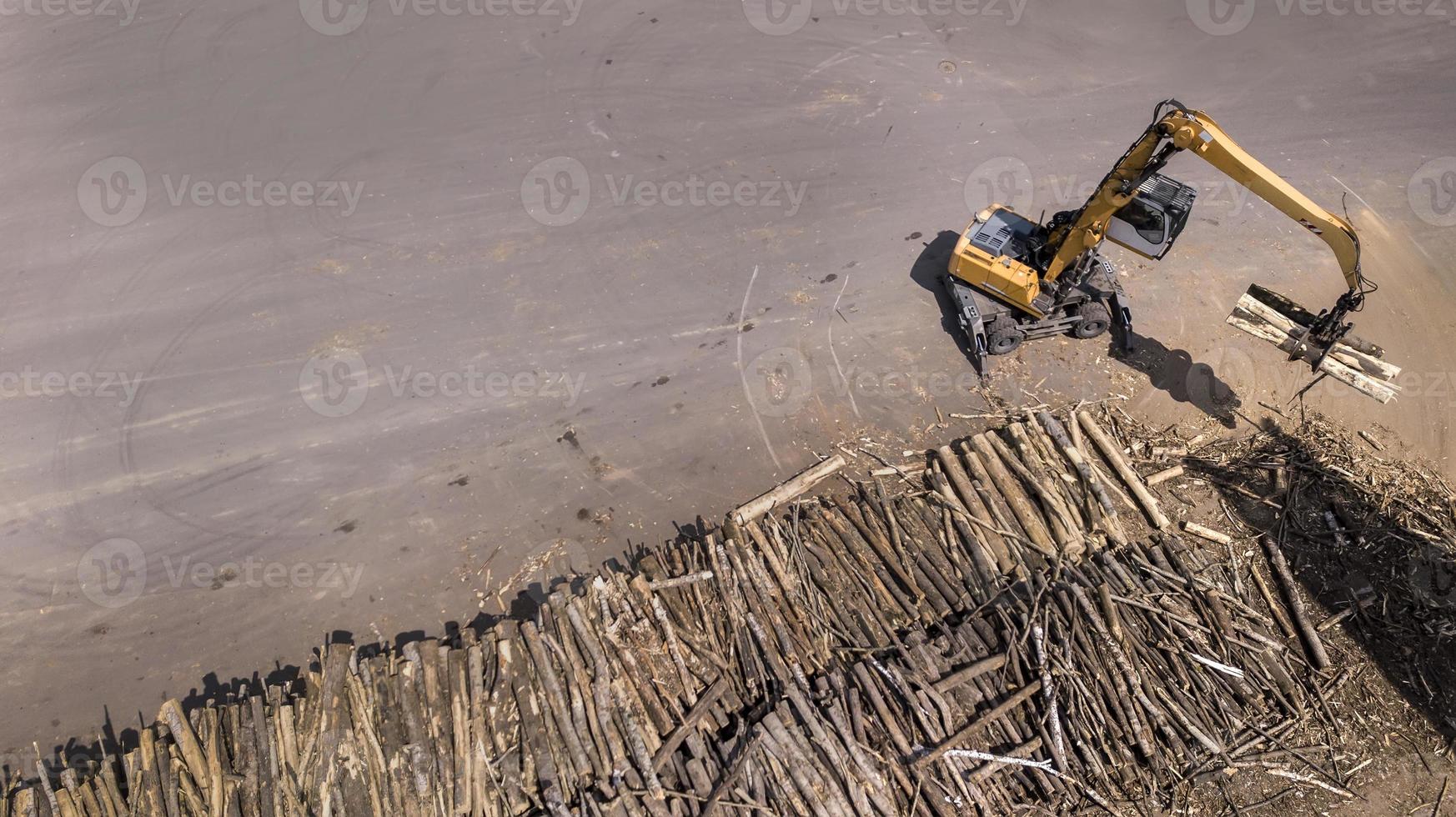 le chargeur charge les poutres en bois dans le camion photo