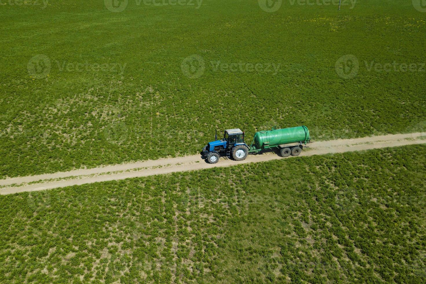 tracteur avec remorque fertilisant le champ avec du fumier naturel photo