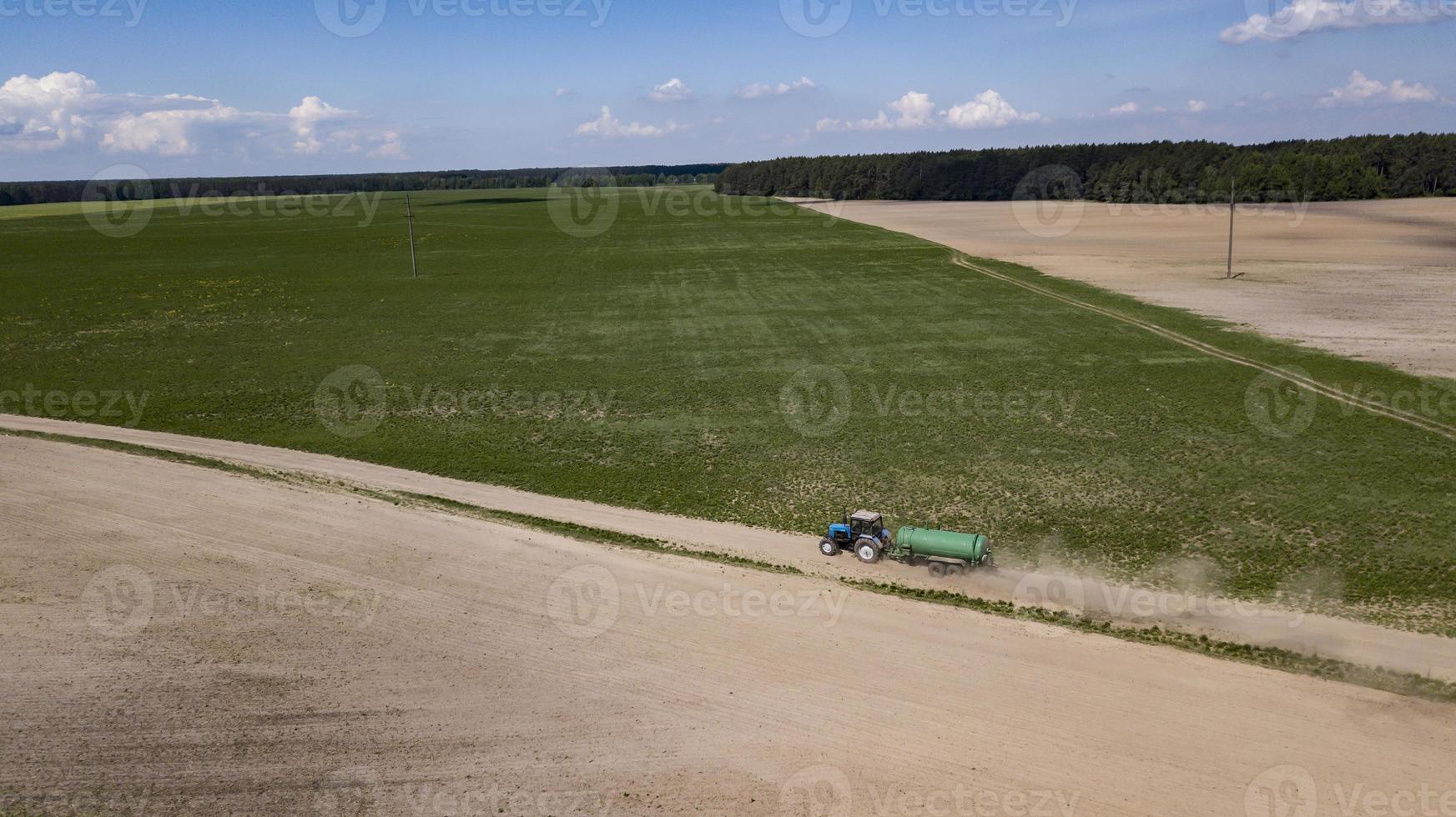 Engrais organique conduit par tracteur sur le terrain photo