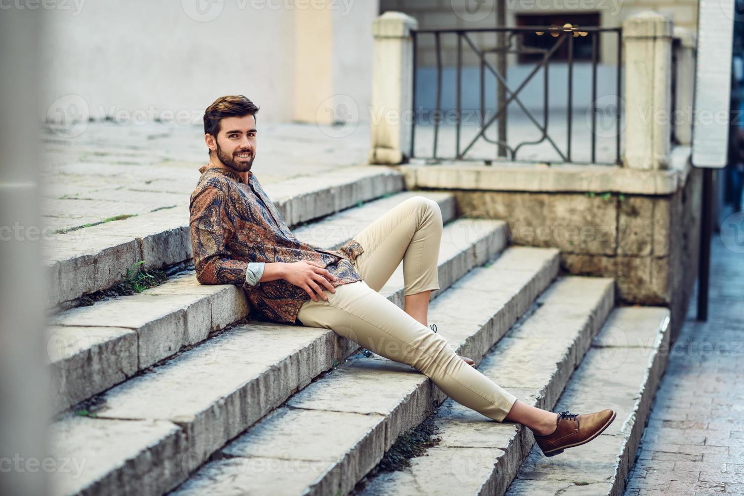 jeune homme barbu, modèle de mode, portant une chemise en milieu urbain. photo