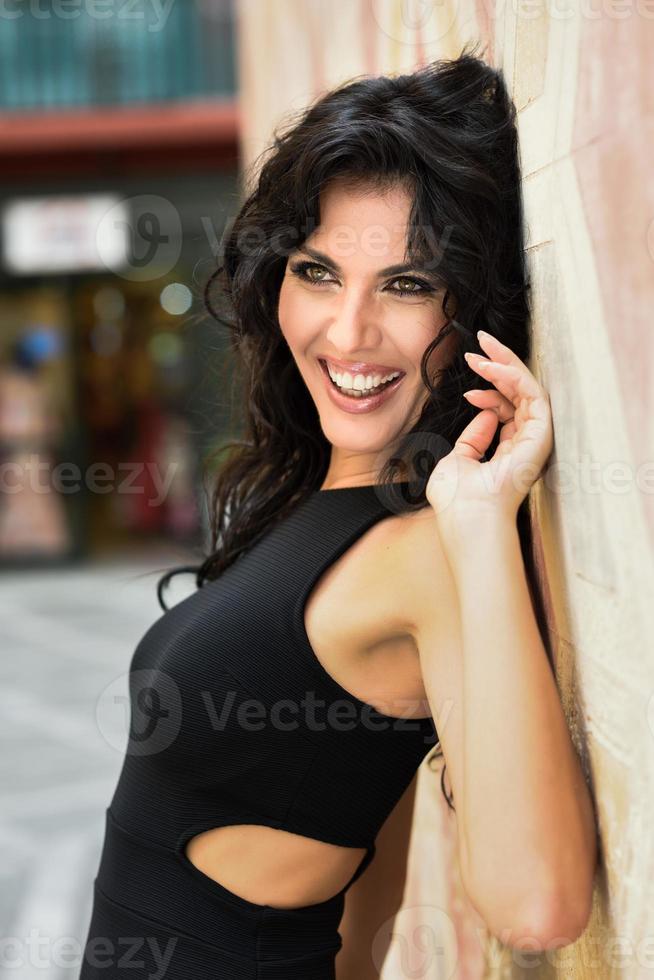 femme brune portant une robe séduisante noire dans la rue photo