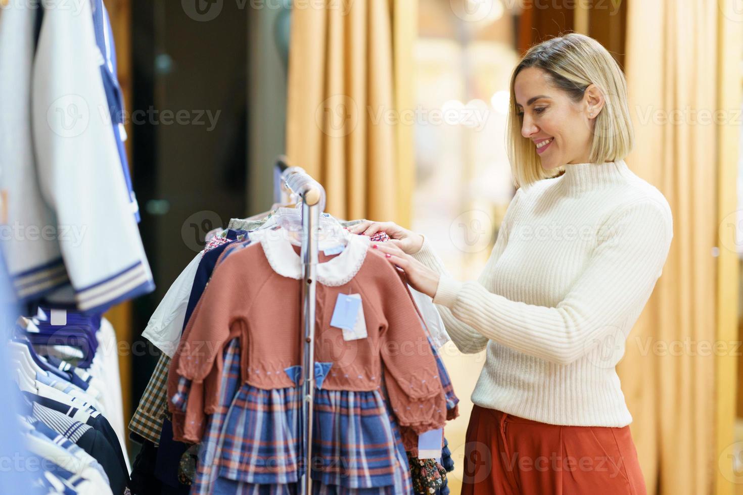 content femme choisissant des vêtements pour petite fille photo