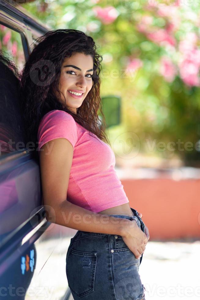 jeune femme dans un camping-car dans un beau camping avec des fleurs roses photo