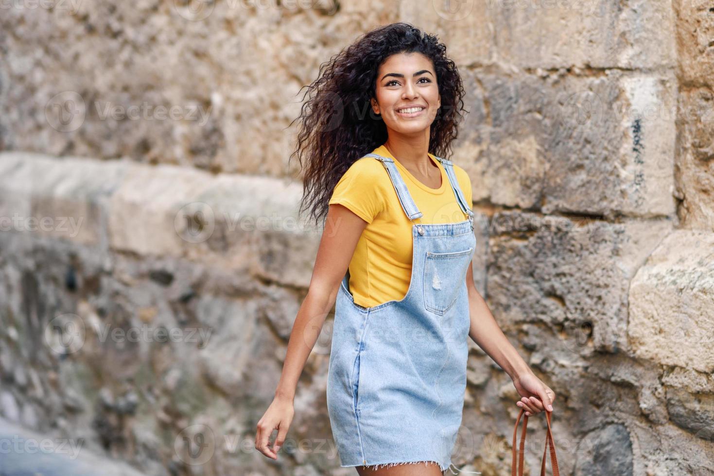 jeune femme touriste noire avec une coiffure frisée à l'extérieur photo