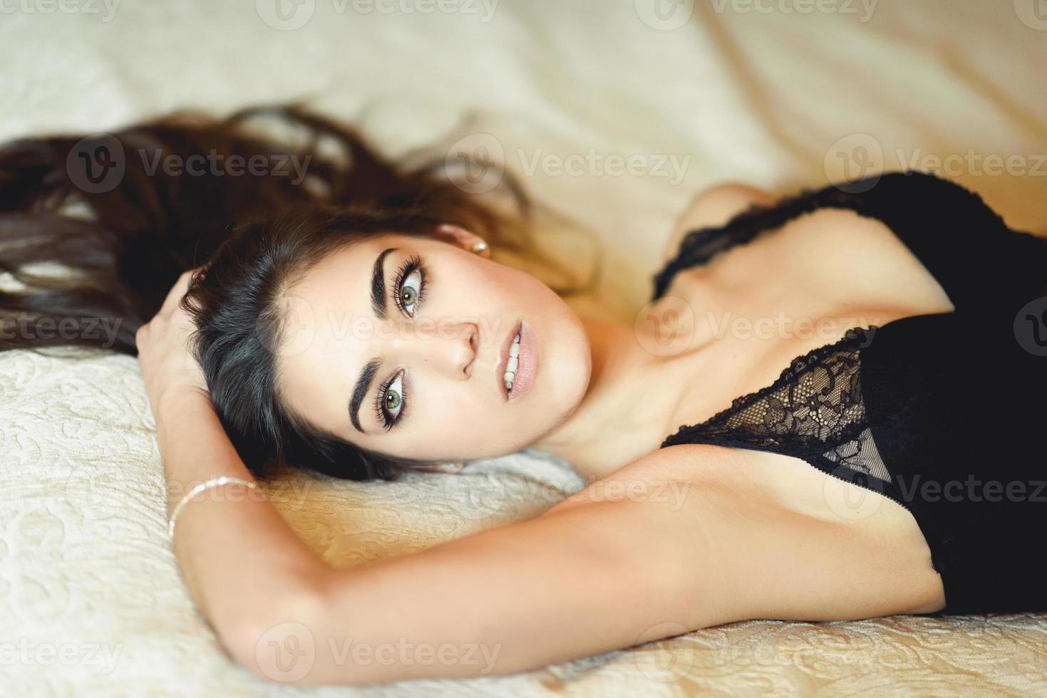 sexy jeune femme en lingerie posant sur le lit photo