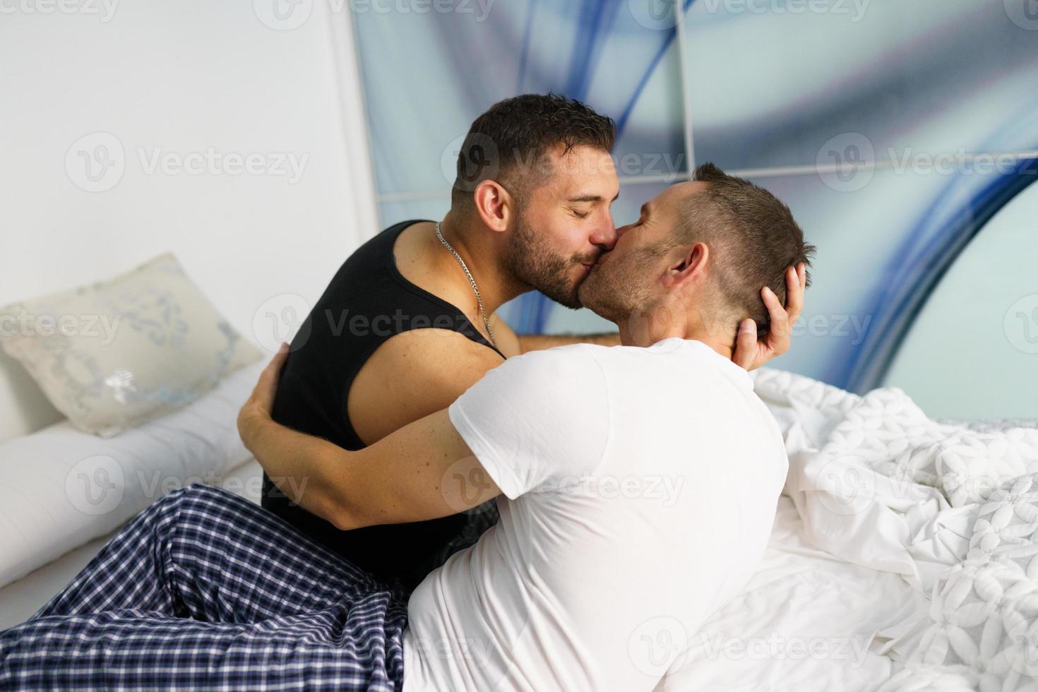 couple gay s'embrassant sur leur lit. concept lgtb. photo