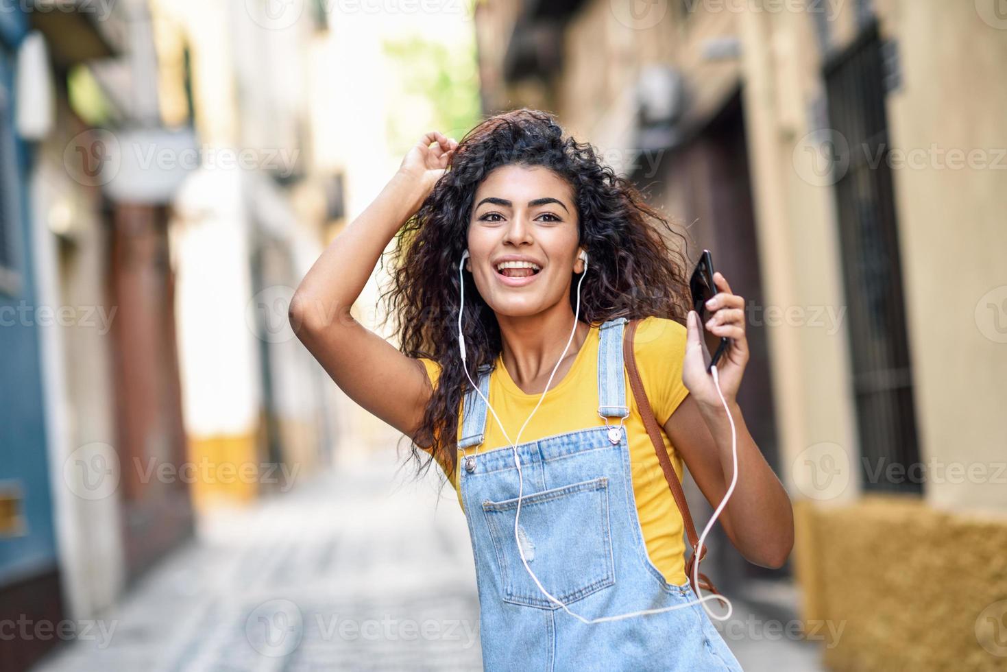 jeune femme arabe écoutant de la musique avec des écouteurs à l'extérieur photo