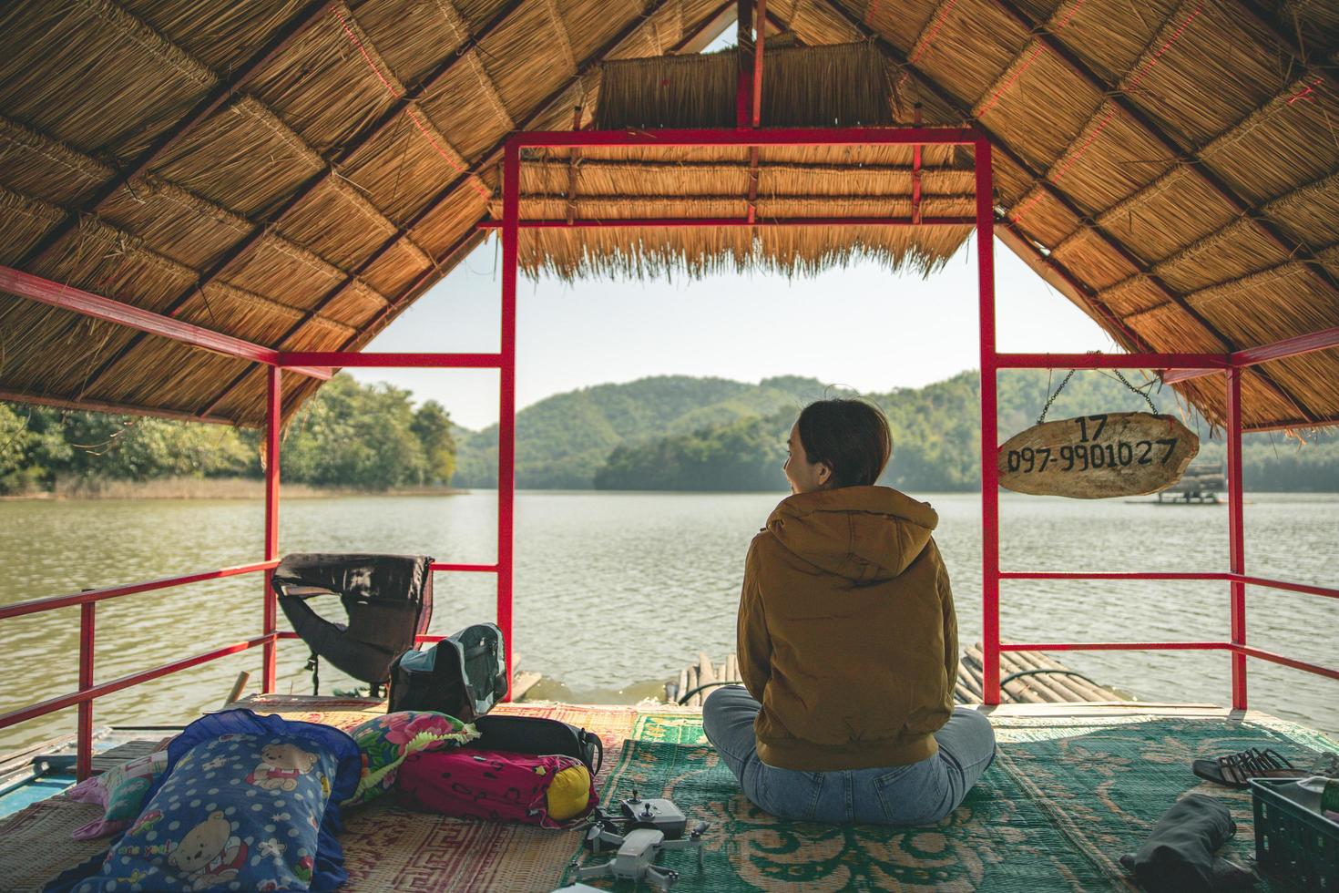 province de loei, thaïlande décembre 2021 femme dans la région du réservoir de huai krathing avec abri en radeau de bambou pour le rafting et manger. beau paysage naturel de la rivière et de la montagne avec un ciel bleu photo