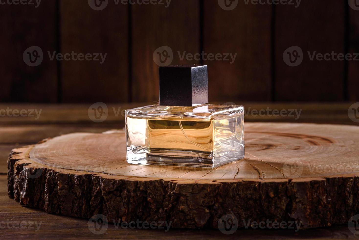 flacon de parfum en verre avec brin de romarin sur podium en bois photo