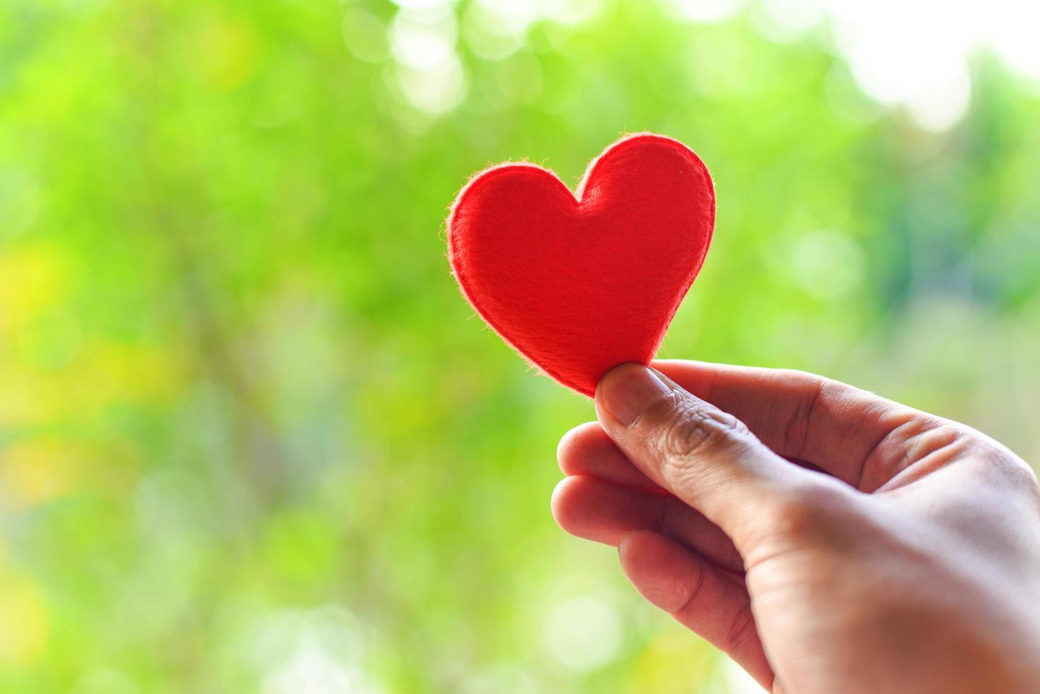 coeur à portée de main pour le concept de philanthropie - femme tenant un coeur rouge dans les mains pour la saint valentin ou faire un don aidez à donner de la chaleur à l'amour prenez soin de vous photo