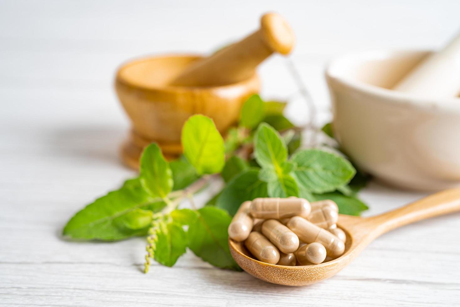 médecine alternative capsule bio à base de plantes avec des suppléments naturels de feuilles d'herbes pour une bonne vie saine. photo