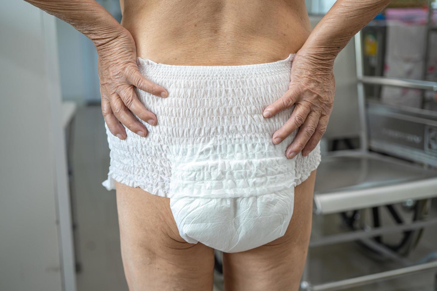 Patiente asiatique âgée ou âgée de vieille dame portant une couche d'incontinence dans une salle d'hôpital de soins infirmiers, concept médical solide et sain. photo