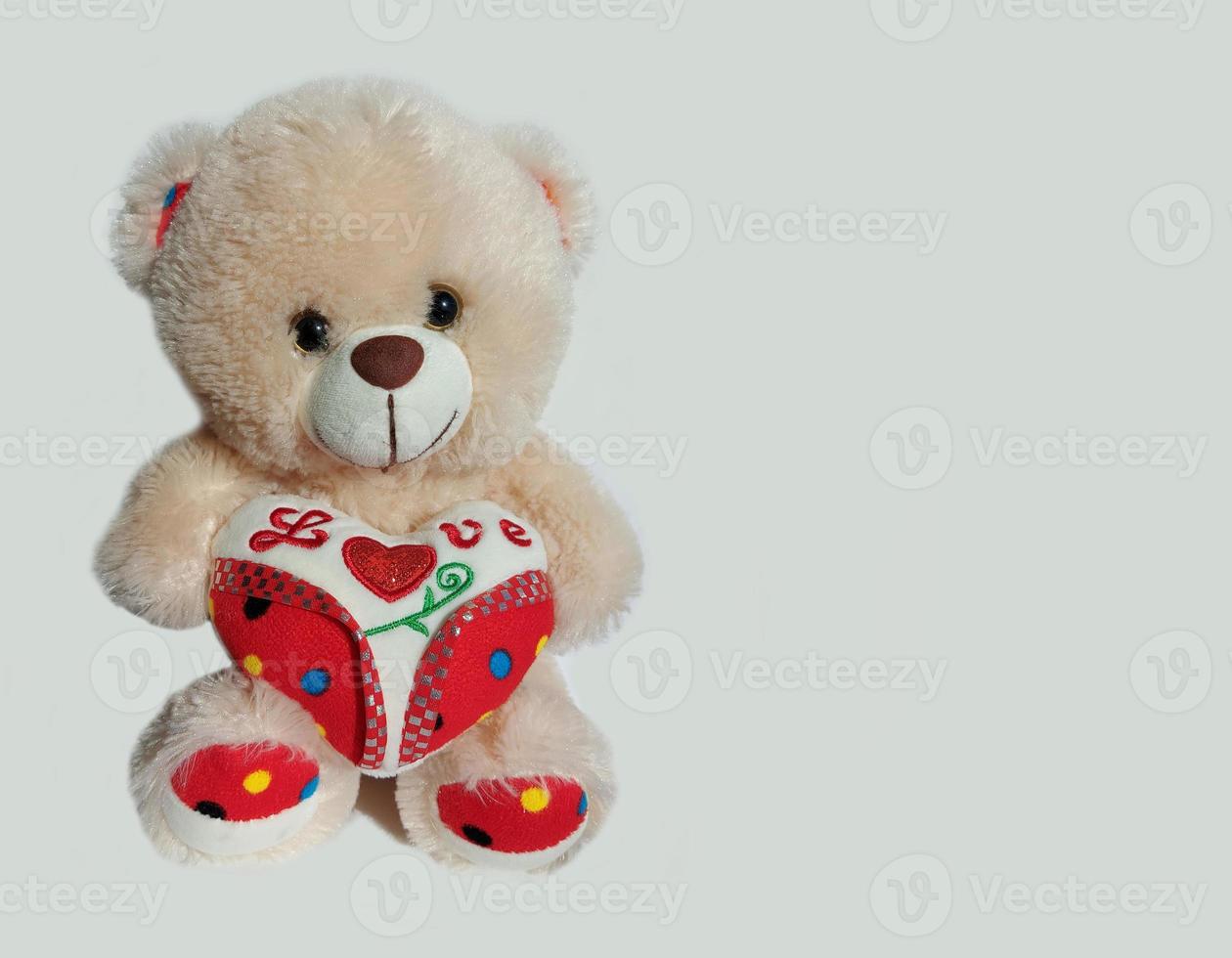 ours en peluche avec un coeur sur fond gris avec place pour le texte. bannière, saint valentin, amour, jouet, cadeau. photo