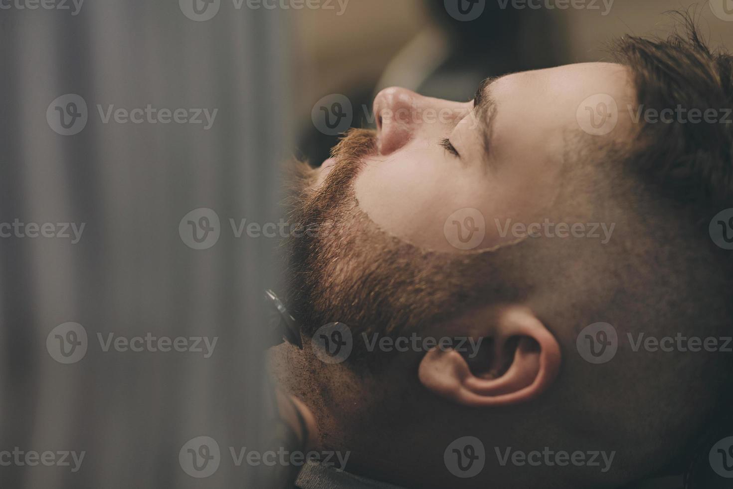 coiffeur professionnel coupe la barbe d'un homme je photo