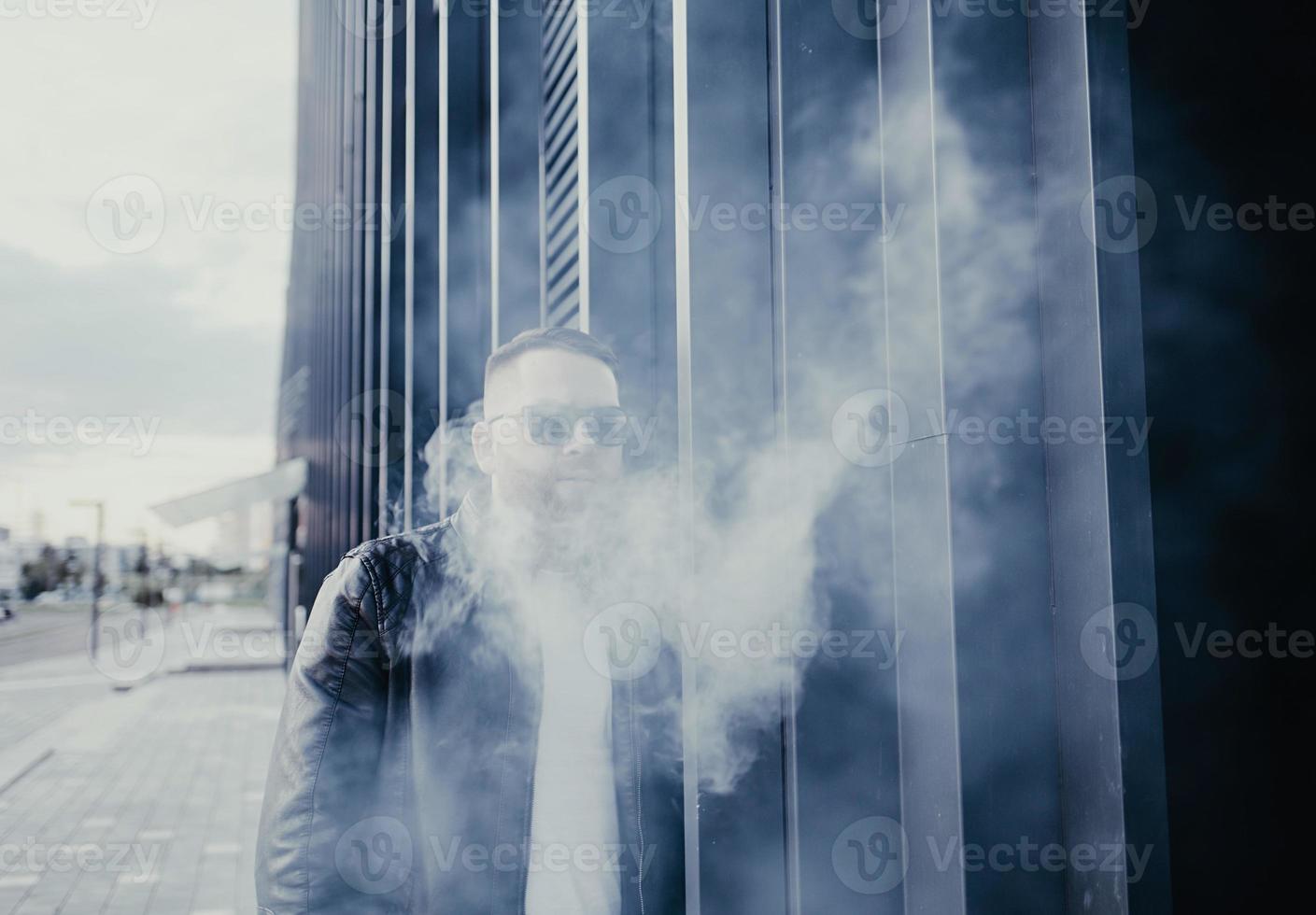 beau mec fumant une cigarette électronique photo