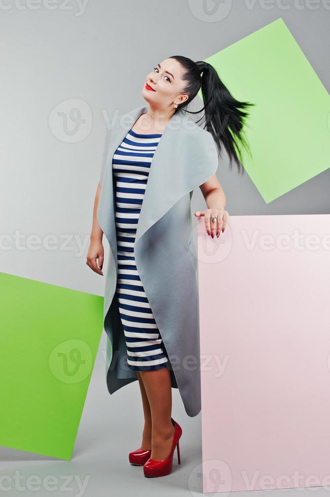 portrait de jeune femme avec bannière rose et verte vierge, planche sur gris isolé. photo