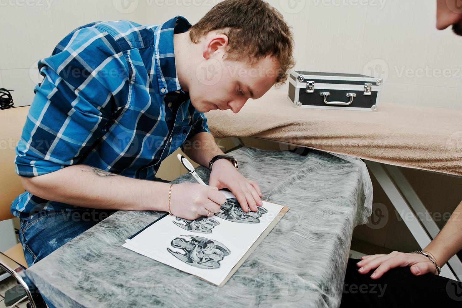 maître de tatouage préparant un croquis pour le tatouage photo