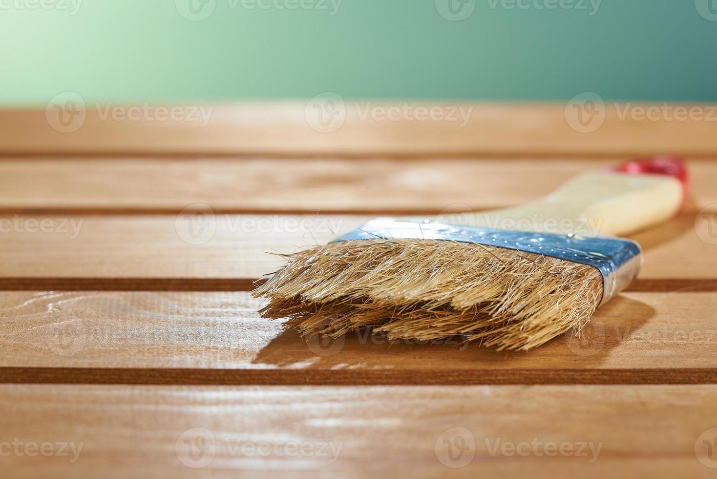 vernir le bois naturel avec un pinceau. pinceau sur une surface en bois. photo