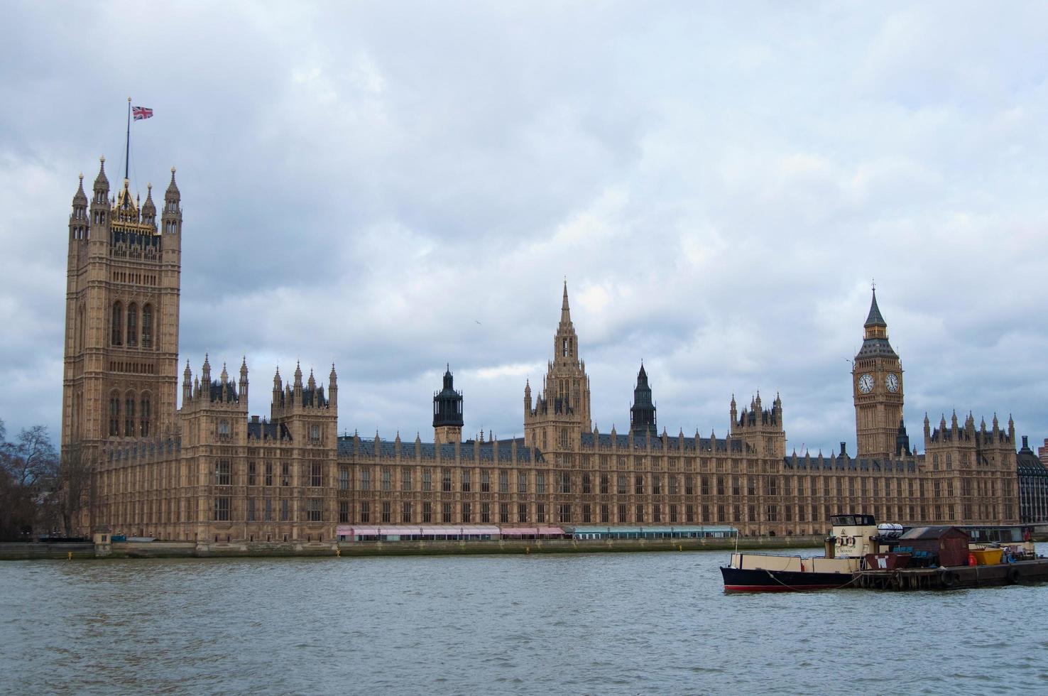 belle vue sur les rives de la tamise, avec les maisons du parlement et big ben. temps nuageux. Londres, Royaume-Uni photo