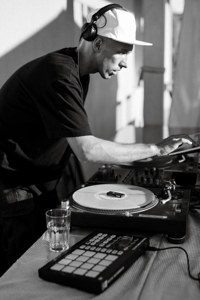DJ dans un casque joue lors d'un événement sur des disques vinyles photo