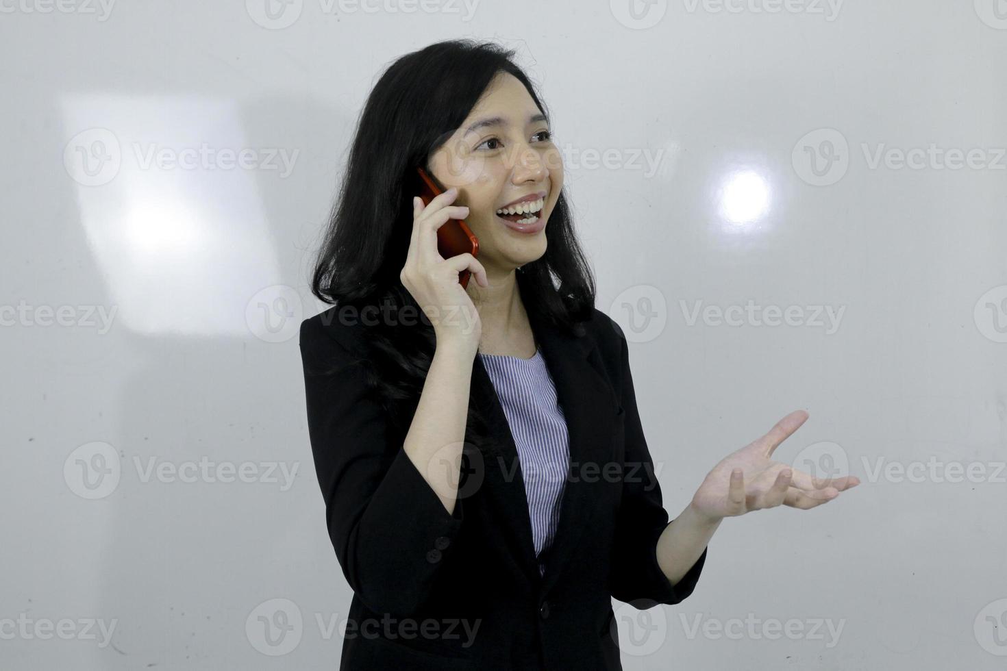 une jeune fille asiatique d'affaires est heureuse d'utiliser un ordinateur portable et de parler au téléphone photo