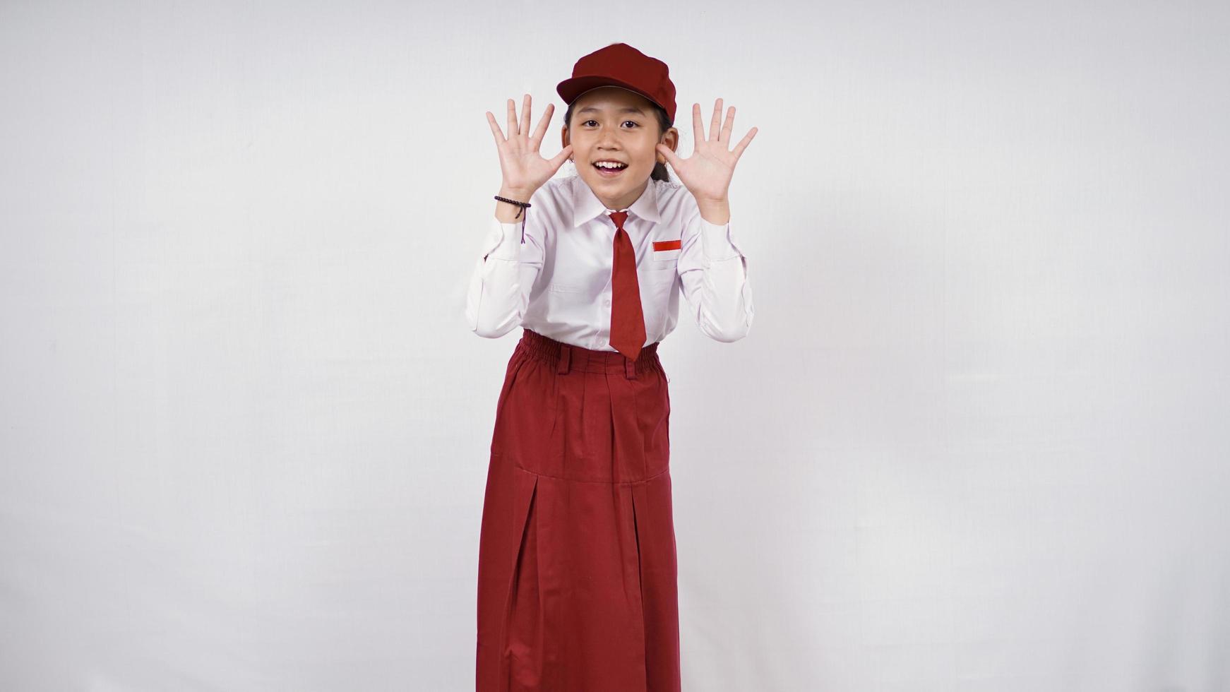 Belle fille de l'école primaire posant joyeusement isolé sur fond blanc photo