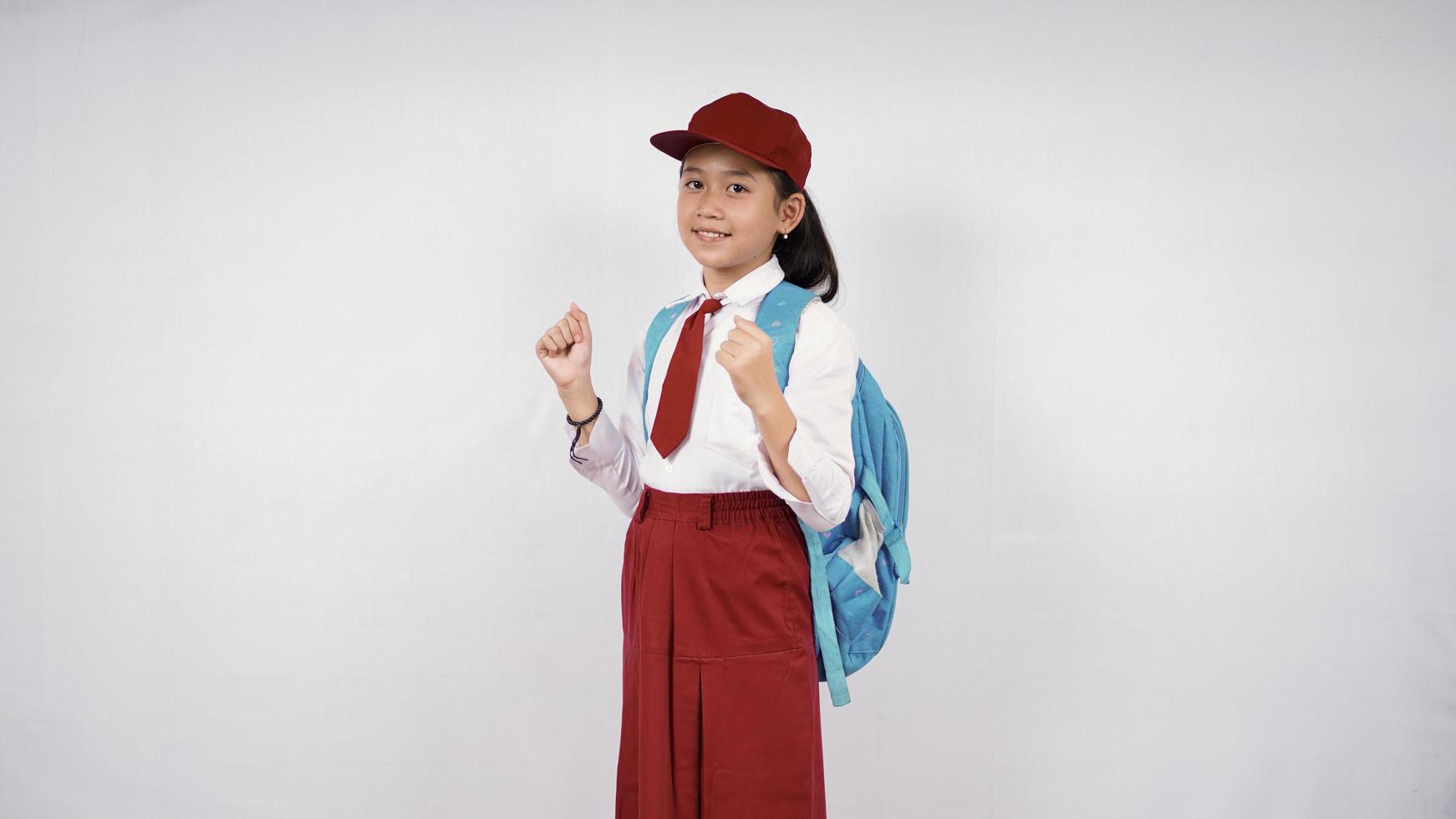 Fille de l'école élémentaire asiatique excité isolé sur fond blanc photo