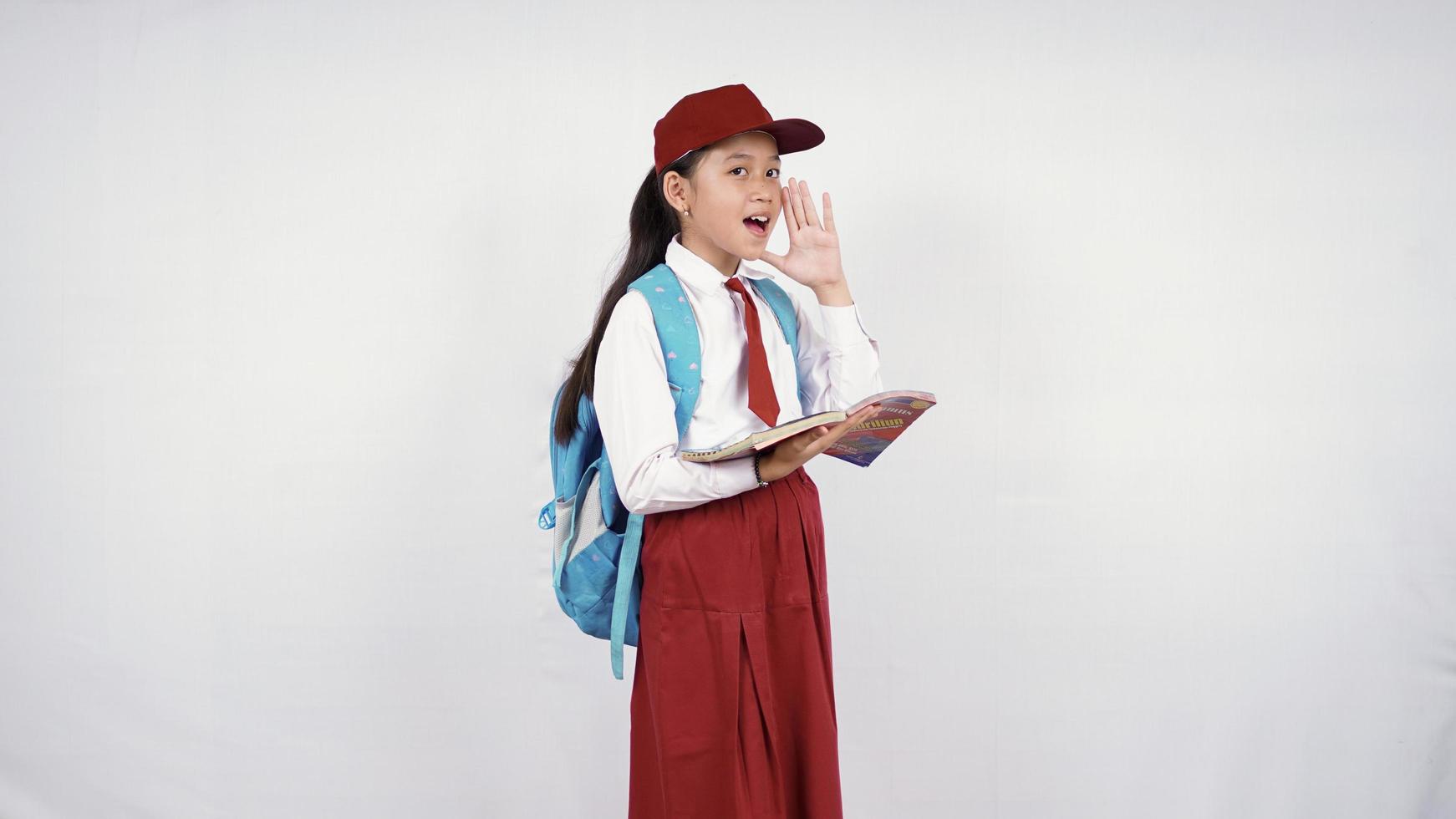 Fille de l'école primaire asiatique criant avec enthousiasme isolé sur fond blanc photo