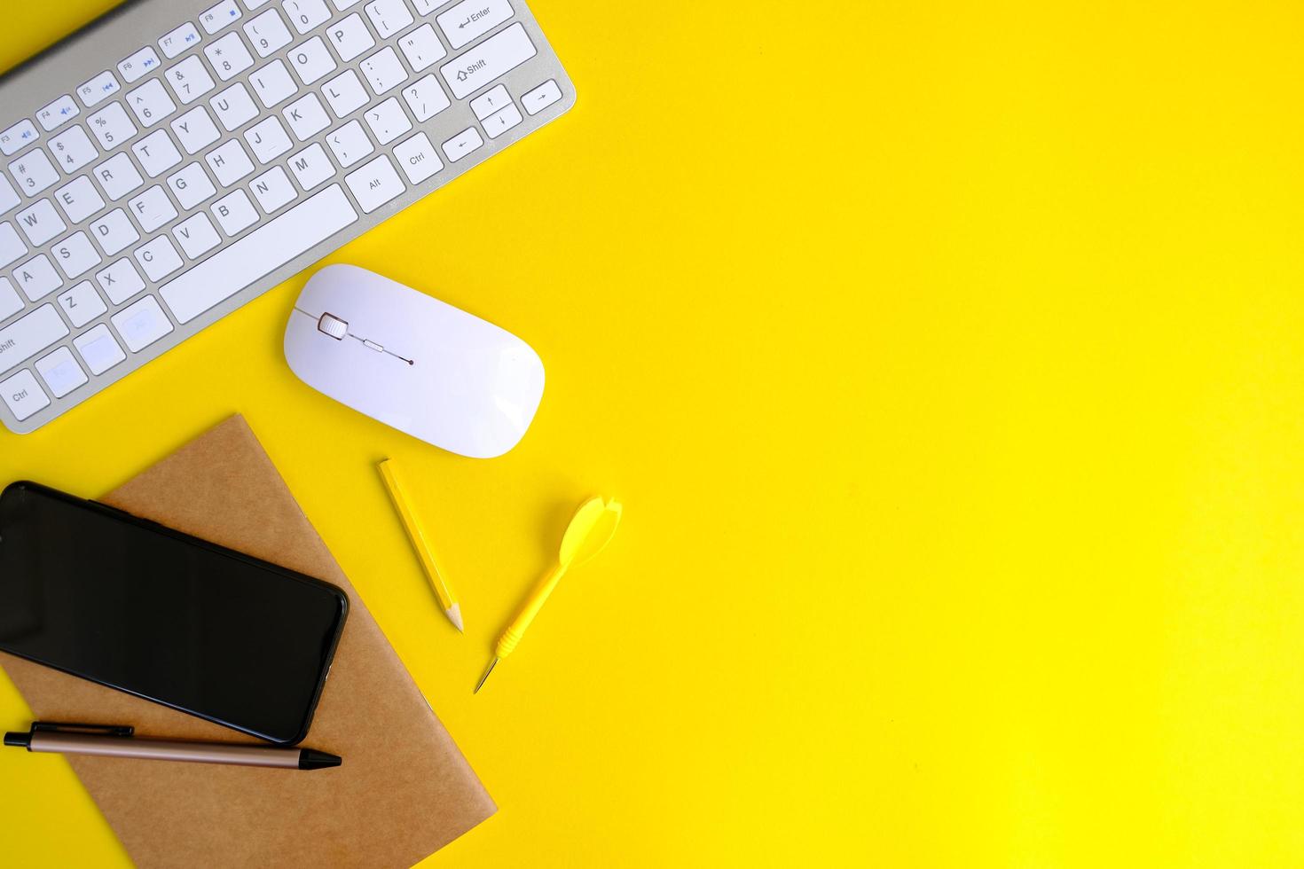 un cahier vierge avec stylo est placé sur une table de bureau avec des outils informatiques et une gamme de matériaux. fond financier et bancaire, mise à plat, vue de dessus photo