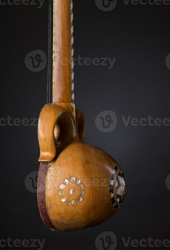 Instrument de musique à cordes asiatique ancienne partie sur fond noir avec rétro-éclairage photo