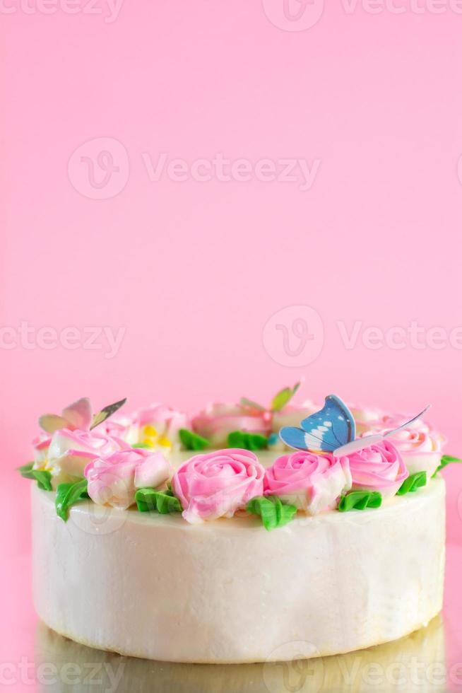 crème au beurre de roses roses décorées oo gâteau d'étang à la vanille sur fond rose avec espace de copie servi dans la fête d'anniversaire et le mariage. délicieuse boulangerie sucrée pour quelqu'un que vous aimez. photo