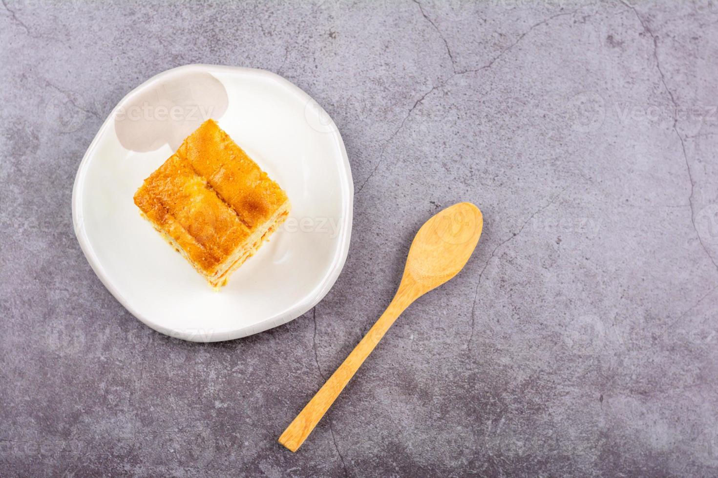 gros plan coupe carrée de gâteau aux carottes sucré et solf fait maison sur  une plaque blanche avec une cuillère en bois sur la table. boulangerie  délicieuse et saine. 6035872 Photo de