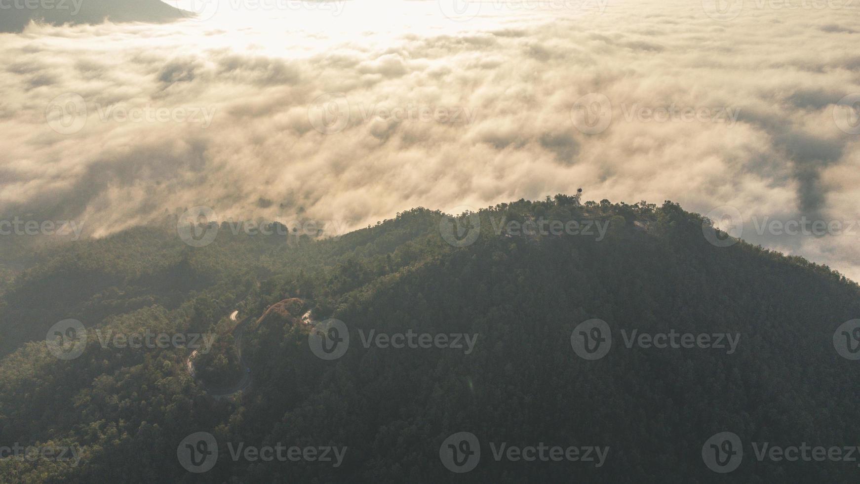 mer de brouillard couvre la zone au sommet de la colline doi phu thok, chiang khan, loei, thaïlande avec fond de lever de soleil en hiver. photo