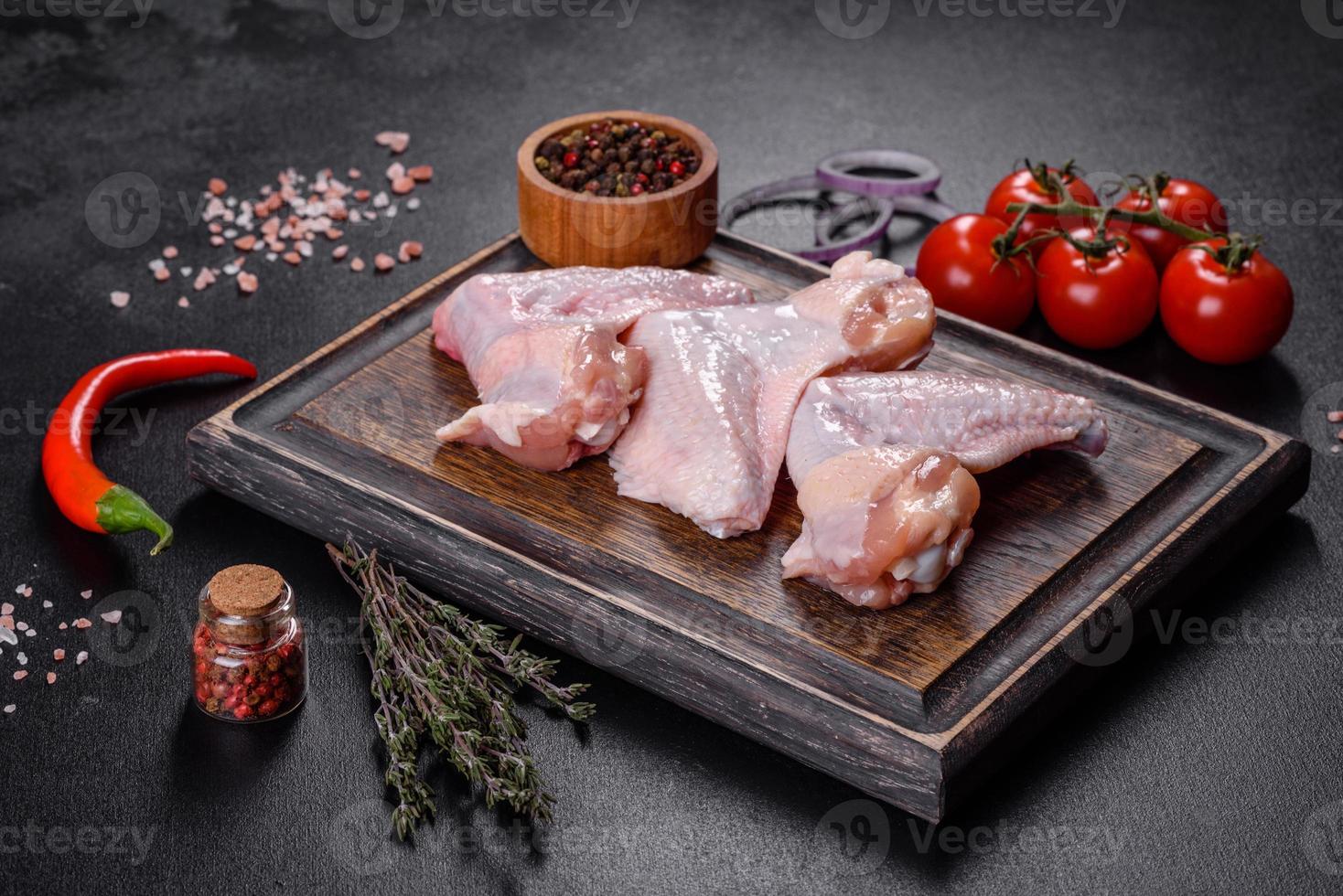 les ailes de poulet se trouvent sur une planche de bois sur fond noir photo