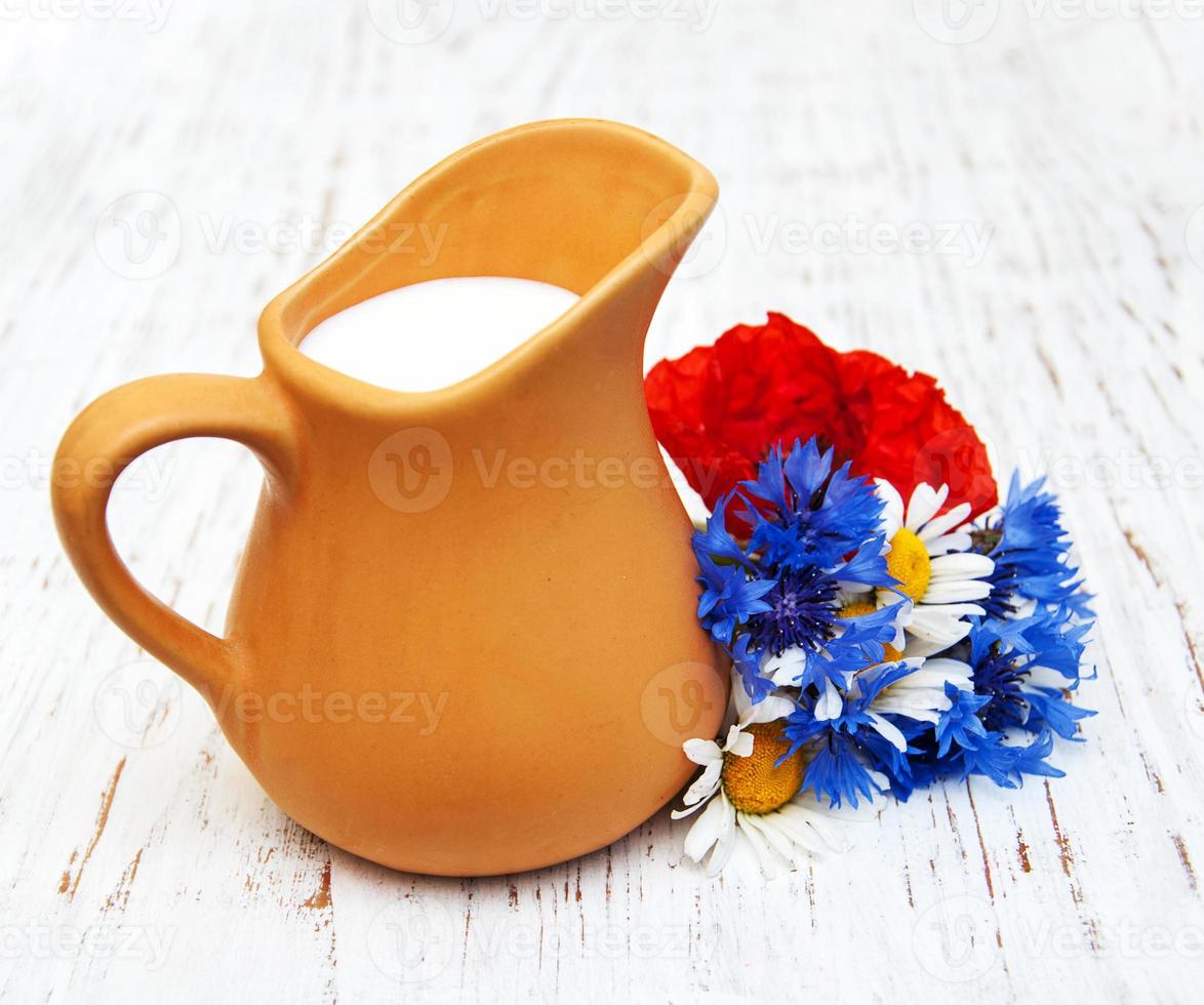 pot de lait et fleurs sauvages photo